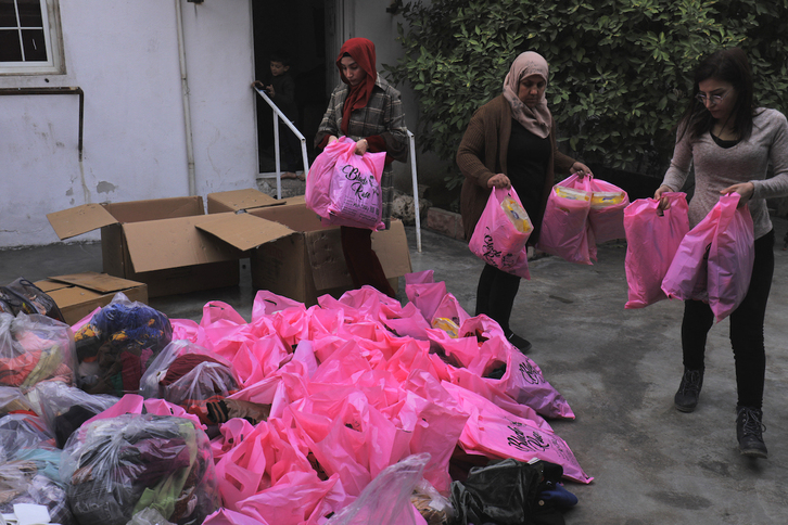 Mujeres kurdas recogen y clasifican ropa en Qamishlo para distribuirla entre los kurdos desplazados de las zonas rurales de Alepo.