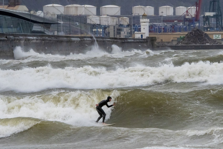 Pese al temporal, ha habido quien se ha atrevido a surfear en la playa de Ereaga, en Getxo.