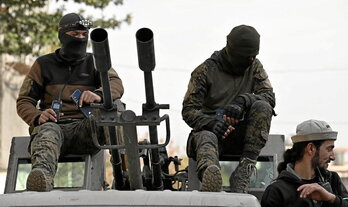 Grupos armados, en un vehículo militar, en las calles de Damasco.