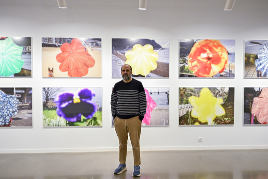 Ricardo Cases, junto a la serie fotográfica protagonizada por los paraguas y las flores.