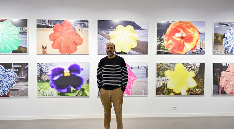 Ricardo Cases, junto a la serie fotográfica protagonizada por los paraguas y las flores.