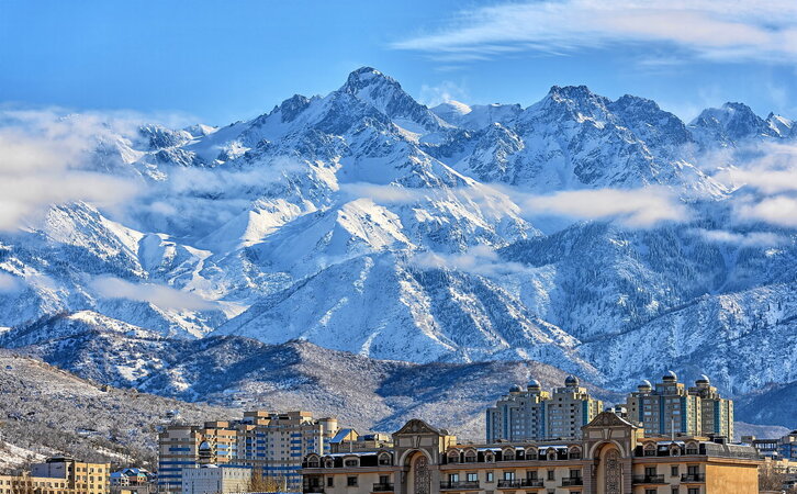 Trans-Ili Que mendiaren tontorrak eta Kazakhstango Almaty hiriaren zati bat, egun eguzkitsu batean, elurte baten ondoren. (Max Zolotukhin | Getty Images)