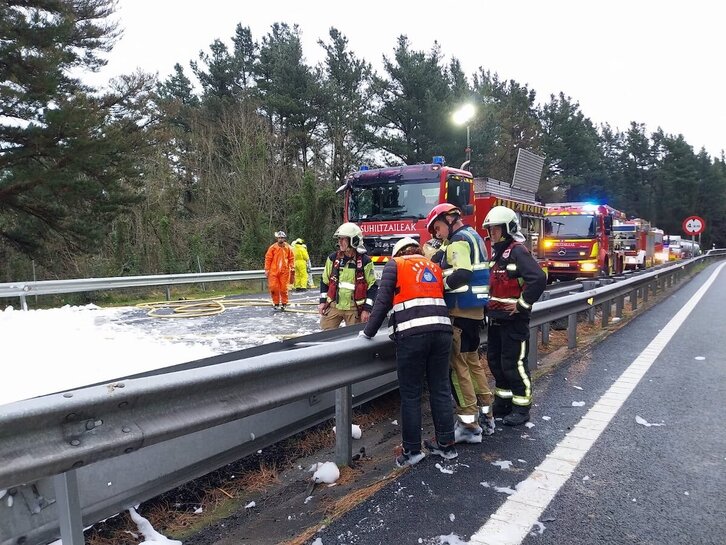 Bomberos y técnicos trabajan en el lugar donde ha volcado el camión.