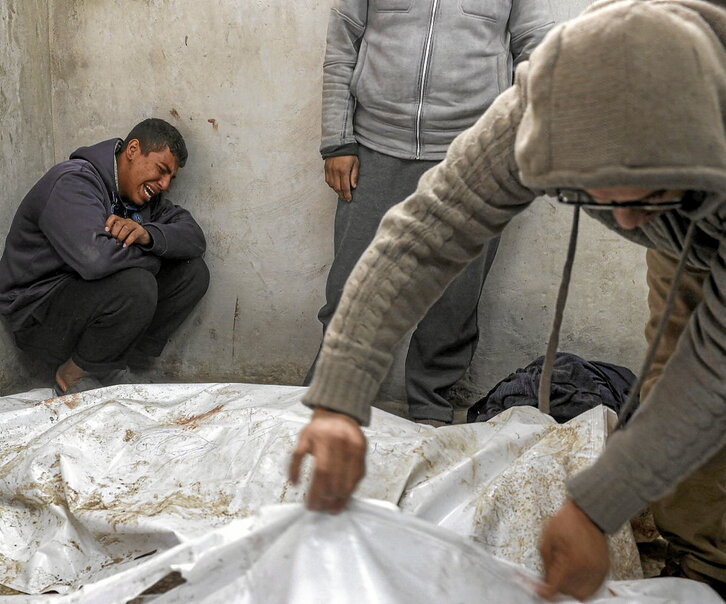 Un joven llora junto a varios cuerpos en la morgue del hospital de los Mártires de Al-Aqsa.