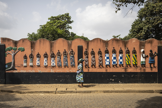 Una mujer camina ante el templo de Ouidah que alberga el festival.