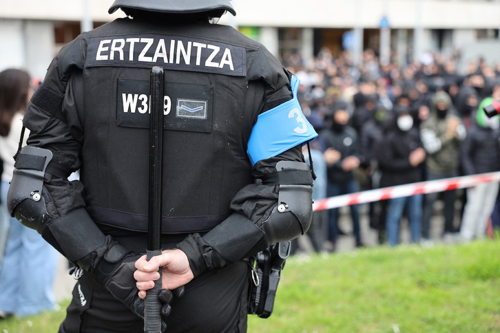 Un agente de la Ertzaintza, porra en mano, observa una de las protestas contra el desalojo.