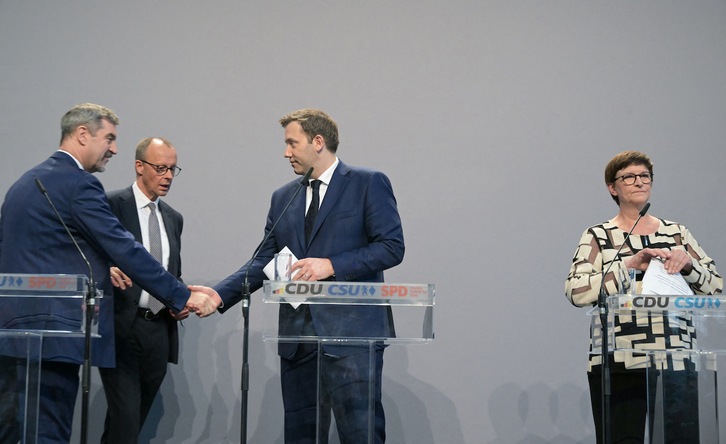Markus Söder (CSU), Friedrich Merz (CDU) y Lars Klingbeil (SPD) se saludan en presencia de Saskia Esken, copresidenta del SPD.