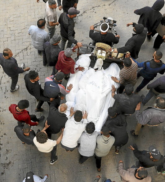 Palestinos transportan los cuerpos de varias víctimas en Ciudad de Gaza.