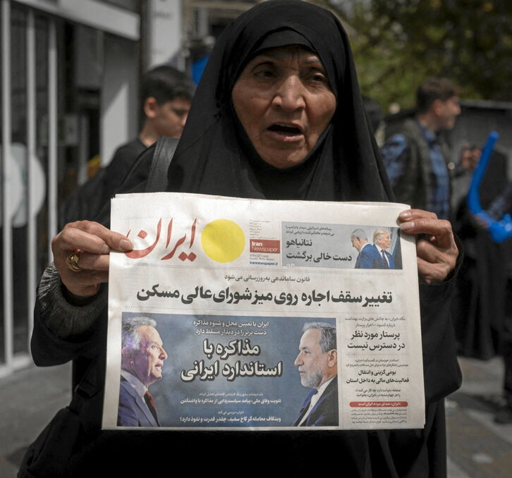 Una mujer sostiene un diario con las imágenes de Witkoff y Araqchi.