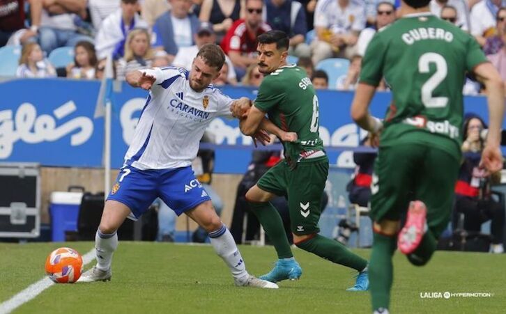 Sergio intenta evitar que Soberón controle el balón.