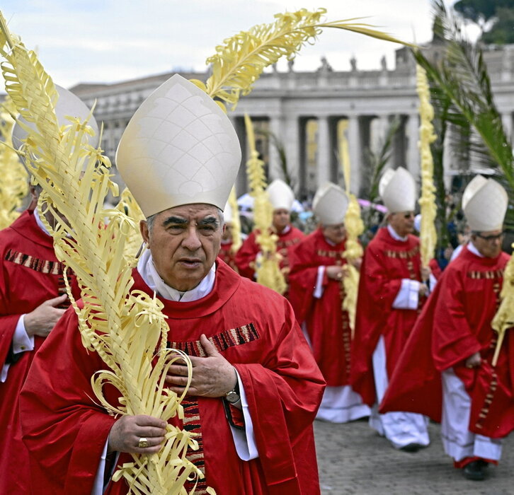 El cardenal Angelo Becciu encabeza la procesión del Domingo de Ramos en la plaza de San Pedro.