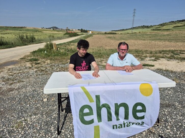Patxiku Irisarri y Fermín Gorraiz, en un campo de Muru Artederreta que será afectado por las obras del TAV que se desarrollan al fondo de la imagen.