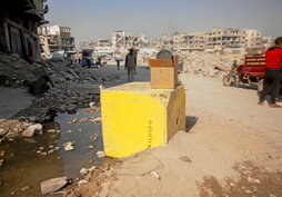 En la página anterior, uno de los bloques que delimita la «línea amarilla» en Bureij. Arriba, tiendas de desplazados entre las ruinas de Yabalia.